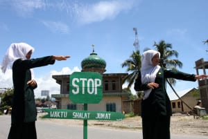 Polisi Syariat (Wilayathul Hisbah) wanita menjaga persimpangan dan mengalihkan jalur lalu lintas di kawasan yang berdekatan dengan masjid saat pelaksanaan ibadah shalat Jumat di Desa Meudang Ara, Blangpidie, Aceh Barat Daya, NAD, Jumat (25/10). Anggota wilayathul Hisbah (WH) wanita setiap pelaksanaan ibadah jumat ditugaskan untuk menjaga ketenangan beribadah umat muslim sebagai realisasi qanun nomor 11/2002 tentang aqidah, ibadah dan syiar islam. ANTARA FOTO/Irwansyah Putra/ed/pd/13.